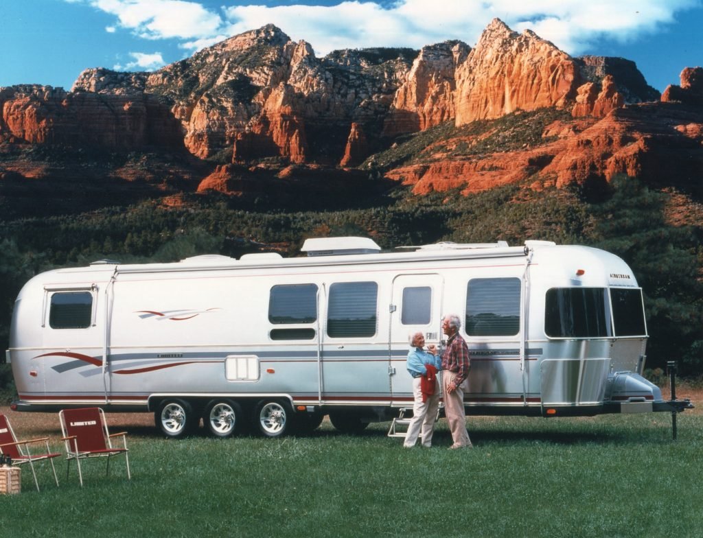 The most luxurious Airstream trailer, the Limited, even came with branded folding chairs. The couple in this photo look happy as they camp near a beautiful mountain range. 