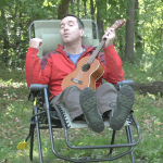 playing ukulele in a camping chair