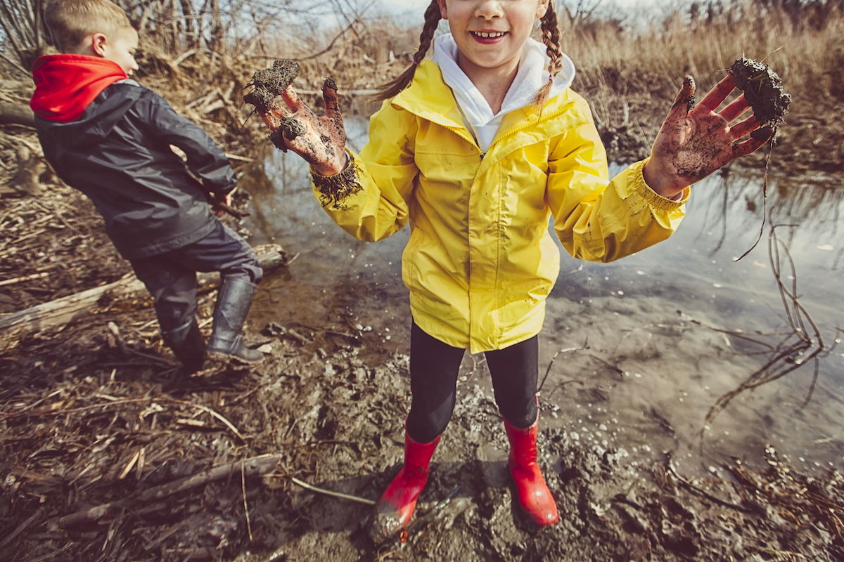 Girl and boy playing in mud