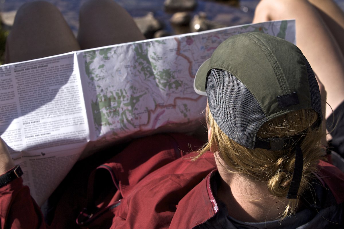 A young woman looks at  a trail map on the Teton Crest Trail.