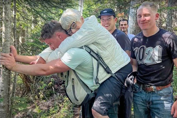 man carries hiker down mountain